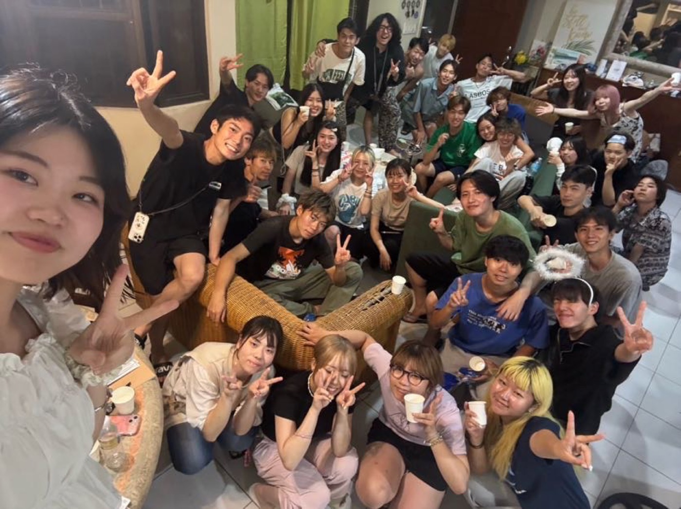 宿泊先の室内で紙コップを手に撮った参加者たちの集合写真(夜)