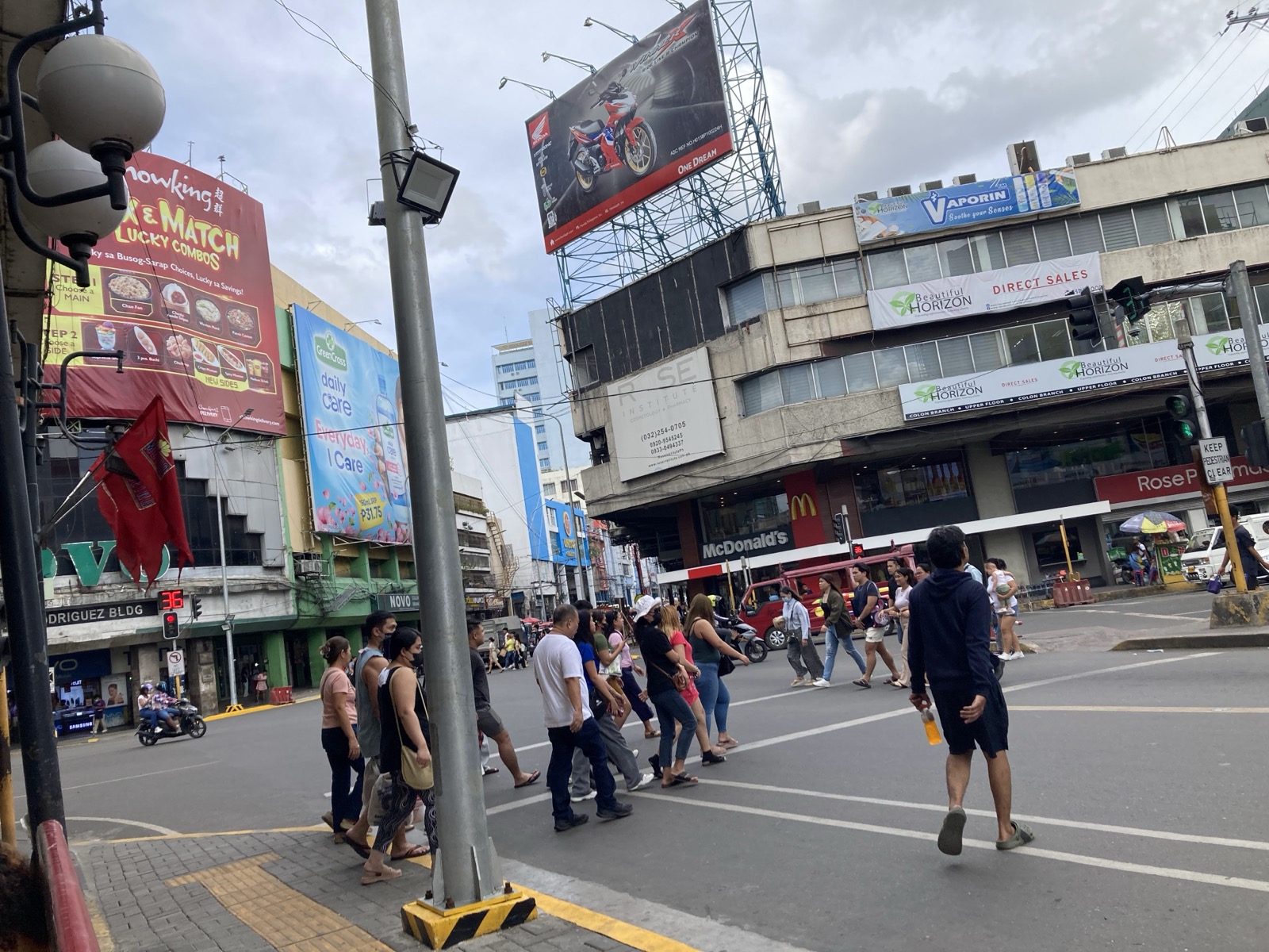 横断歩道のあるセブの街の交差点を歩いて渡る参加者