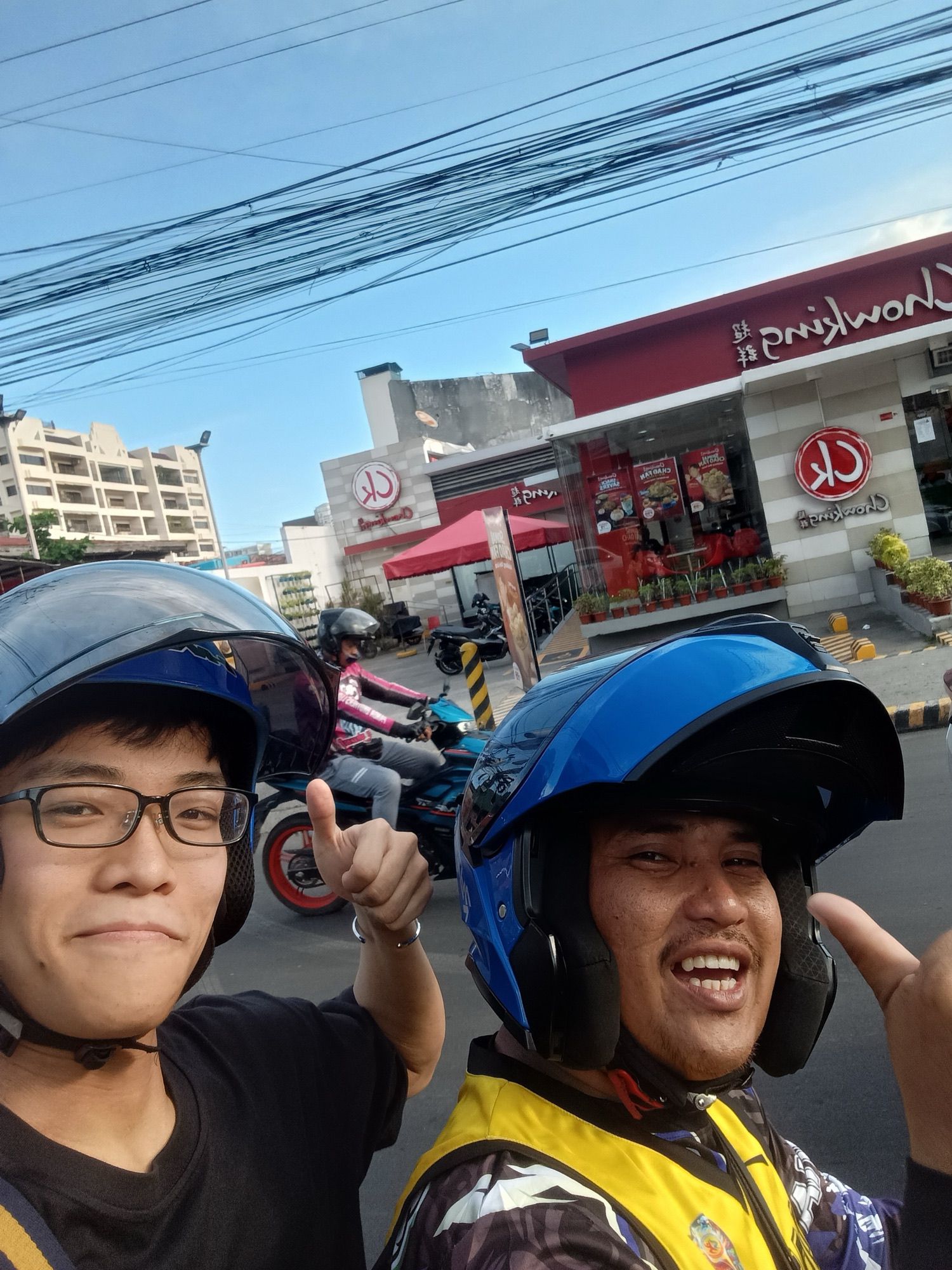 バイクタクシーの運転手と打ち解けて記念に写る参加者