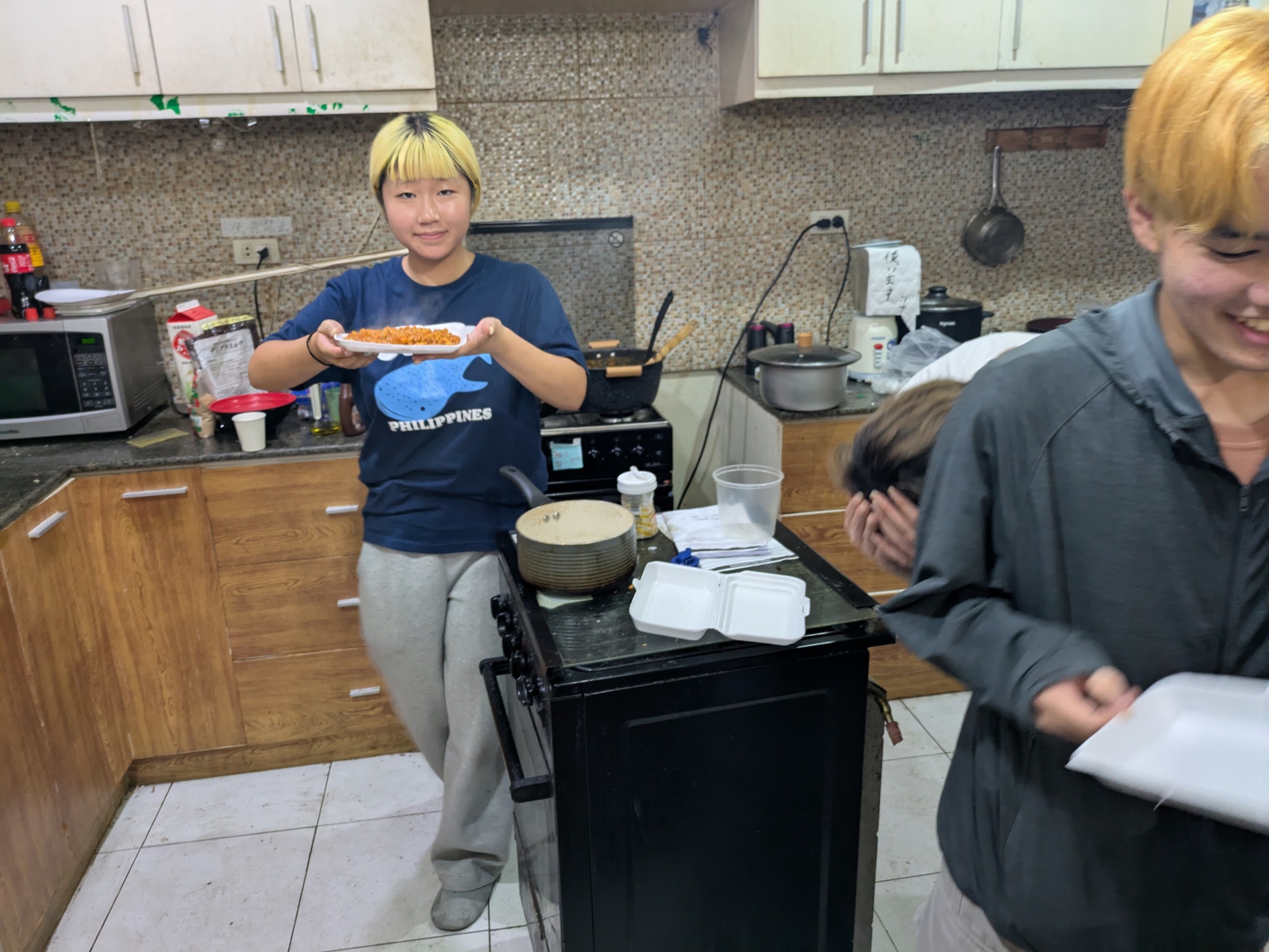 TAMARIBAのキッチンで料理を運ぶ参加者